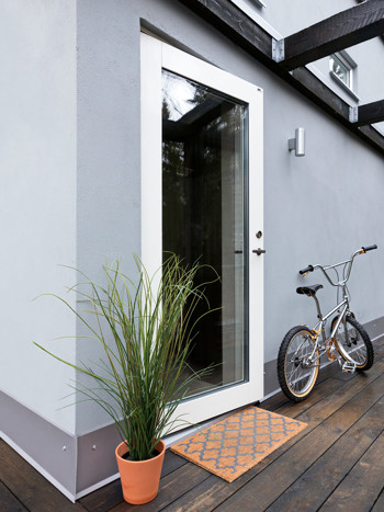 Vit altandörr på grå fasad