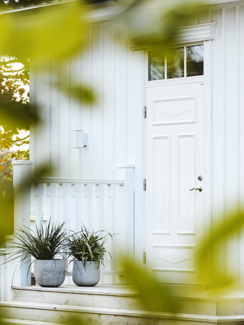 Vit ytterdörr på vit fasad