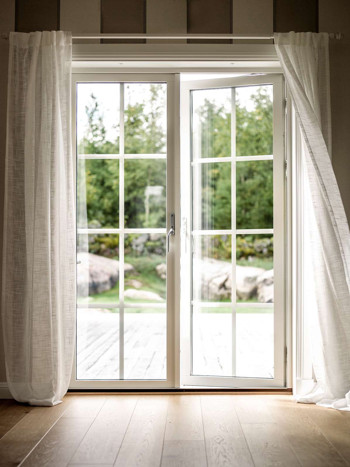 Altandörr med spröjs och vita gardiner