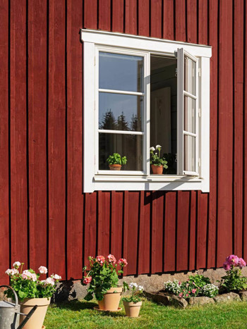 Vitt allmogefönster på röd stuga