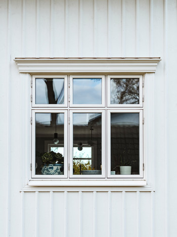Vita traditionella fönster med spröjs